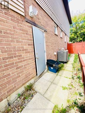 Ajax (Central) apartment for rent - A red brick building with a white door and a small window.