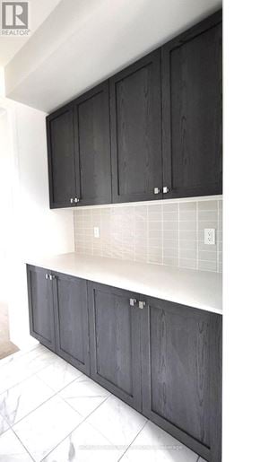 Whitby (Port Whitby) townhouse for rent - A kitchen with black cabinets and a white counter.