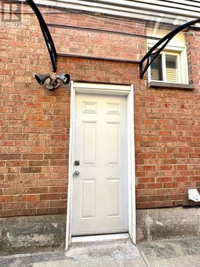 Toronto (Milliken) apartment for rent - A white door is closed with a black security camera mounted on the wall above it.