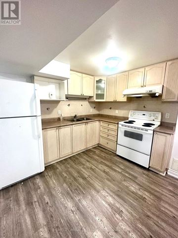 Toronto (Milliken) apartment for rent - A kitchen with wood floors and white appliances.