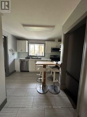 Barrie (Allandale Heights) apartment for rent - A kitchen with a table and chairs in the middle of the room.