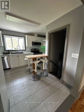 Barrie (Allandale Heights) apartment for rent - A kitchen with a table and chairs in the middle of the room.