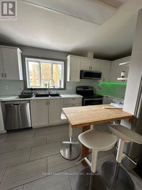 Barrie (Allandale Heights) apartment for rent - A kitchen with a table and chairs in front of a window.