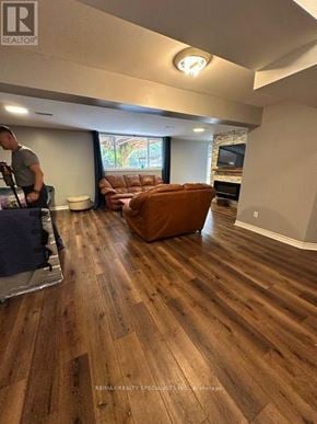 Barrie (Allandale Heights) apartment for rent - A man is working on a piece of furniture in a room with wooden flooring.