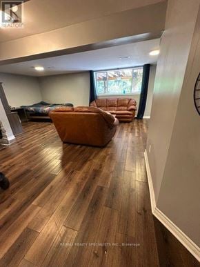 Barrie (Allandale Heights) apartment for rent - A living room with a brown leather couch and a wooden floor.