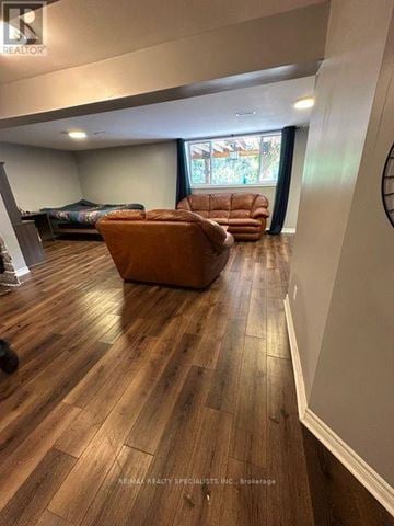 Barrie (Allandale Heights) apartment for rent - A living room with a brown leather couch and a wooden floor.