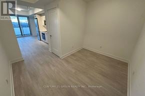 Oshawa (Windfields) condo for rent - A spacious room with light wood flooring and white walls, with a door leading to a balcony.