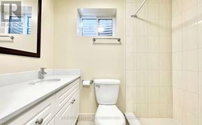 Toronto (Agincourt South-Malvern West) apartment for rent - A white toilet sits in a bathroom with a white sink and a window.