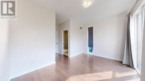 Markham (Wismer) townhouse for rent - A spacious room with a door and a window.