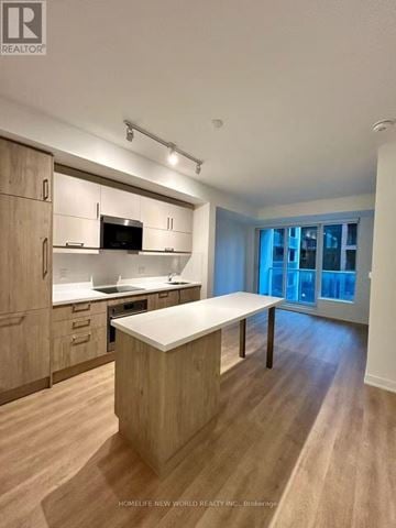 Markham (Unionville) condo for rent - A modern kitchen with wooden cabinets and a white island.