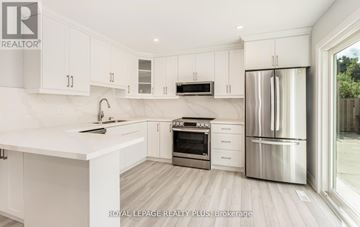 Mississauga (Cooksville) apartment for rent - A modern kitchen with white cabinets and stainless steel appliances.