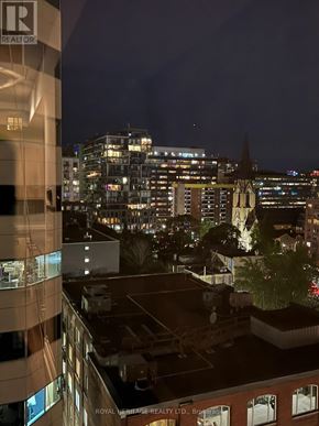 Toronto (Waterfront Communities) condo for rent - A cityscape at night with a building in the foreground that has a sign that says "Royal Heritage Realty Ltd.".