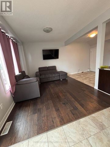 Grimsby (Grimsby Beach) townhouse for rent - A living room with a grey couch and a flat screen TV mounted on the wall.