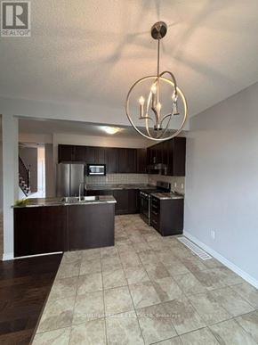 Grimsby (Grimsby Beach) townhouse for rent - A well-lit kitchen with a large island and a hanging light fixture.