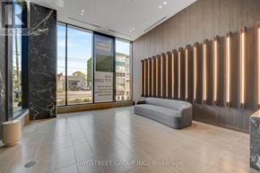 Hamilton (Corktown) condo for rent - A modern office lobby with a reception desk and a large window overlooking the street.