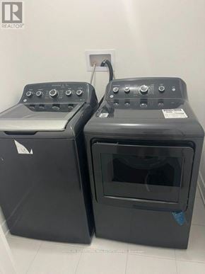 Erin apartment for rent - Two black ovens with control panels on top are in a white room.