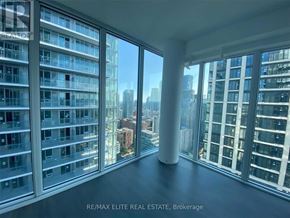 Toronto (Mount Pleasant West) condo for rent - A room with large windows overlooking a cityscape.