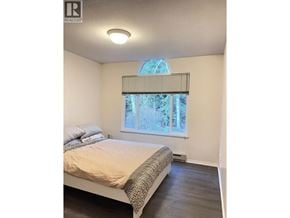 Coquitlam townhouse for rent - A bedroom with a bed, pillows, and a window with blinds.