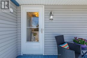 Collingwood apartment for rent - A white door with a glass window is open to a patio with a chair and a table.