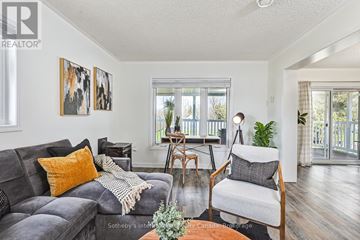Collingwood apartment for rent - A living room with a grey couch and a wooden chair.