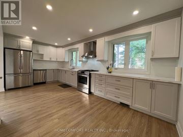 Toronto (Morningside) apartment for rent - A spacious kitchen with wooden floors and white cabinets.