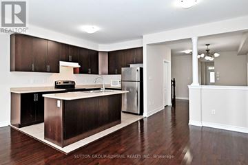 Vaughan (Patterson) townhouse for rent - A kitchen with dark wood cabinets and a white island.