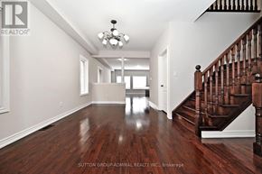 Vaughan (Patterson) townhouse for rent - A spacious room with a wooden floor and a staircase on the right side.