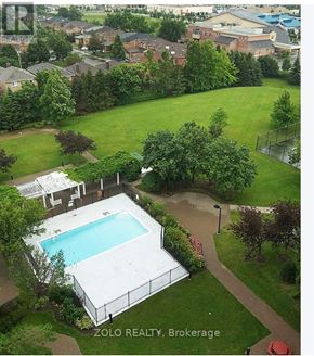 Mississauga (City Centre) condo for rent - A pool surrounded by a fence and trees in a yard.