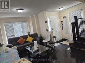 Brampton (Sandringham-Wellington) apartment for rent - A living room with a black couch and a coffee table.