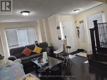 Brampton (Sandringham-Wellington) apartment for rent - A living room with a black couch and a coffee table.