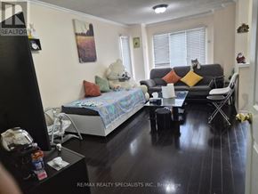 Brampton (Sandringham-Wellington) apartment for rent - A bedroom with a bed, a couch, and a chair.