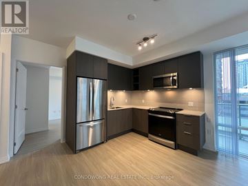 Toronto (Mount Pleasant West) condo for rent - A modern kitchen with dark wood cabinets and stainless steel appliances.