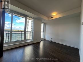 Toronto (Regent Park) condo for rent - A room with a large window overlooking a cityscape.