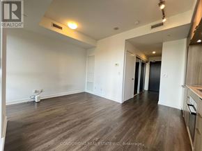 Toronto (Regent Park) condo for rent - A spacious room with wood flooring and white walls.
