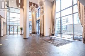 Toronto (Henry Farm) condo for rent - A large, well-lit lobby with a chandelier and a view of the city.