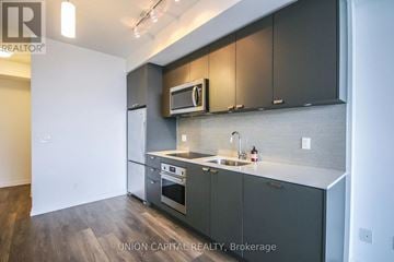 Toronto (Henry Farm) condo for rent - A kitchen with dark grey cabinets and a white countertop.