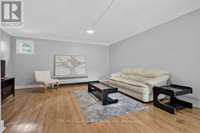 Burlington (Brant) multi-family for rent - A living room with a white sofa and a wooden floor.