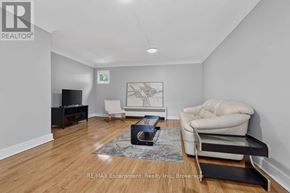Burlington (Brant) multi-family for rent - A living room with a white chair, a black table, and a rug.