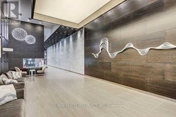 Toronto (Willowdale West) condo for rent - A modern living room with a grey couch and a wooden wall.