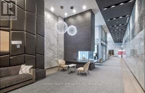 Toronto (Willowdale West) condo for rent - A modern office lobby with a marble wall and a grey carpet.