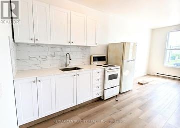 St. Thomas multi-family for rent - A kitchen with white cabinets and a marble backsplash.