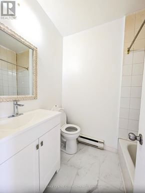 St. Thomas multi-family for rent - A white bathroom with a toilet, sink, and bathtub.