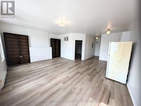 St. Thomas multi-family for rent - A spacious room with wooden flooring and white walls, with a door on the right side.