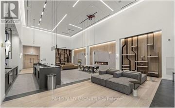 Toronto (Downsview-Roding-Cfb) condo for rent - A modern living room with a grey sofa and a wooden bookshelf.