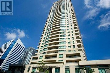 Toronto (Willowdale East) condo for rent - A tall residential building with a blue sky and clouds in the background.