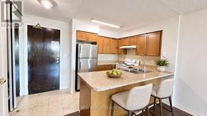 Toronto (Willowdale East) condo for rent - A kitchen with a counter, sink, and chairs.