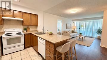 Toronto (Willowdale East) condo for rent - A kitchen with a white stove top oven and white cabinets.