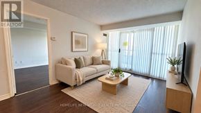Toronto (Willowdale East) condo for rent - A living room with a couch, a coffee table, and a television.