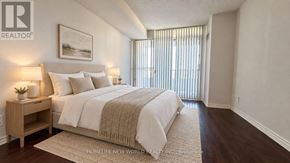 Toronto (Willowdale East) condo for rent - A bedroom with a large bed and a nightstand with a lamp.