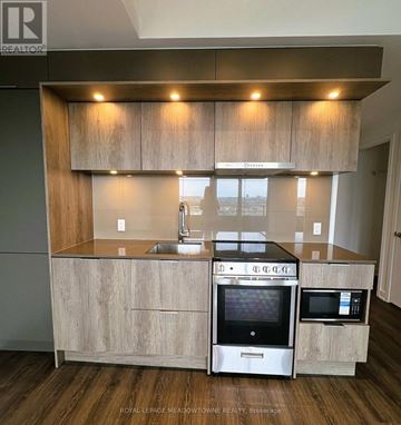 Mississauga (City Centre) condo for rent - A modern kitchen with a sink, stove, and microwave.